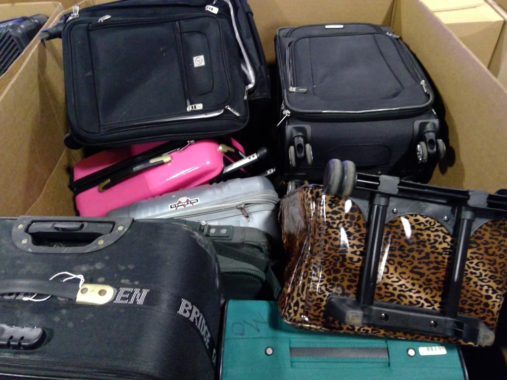 Assorted used suitcases packed together