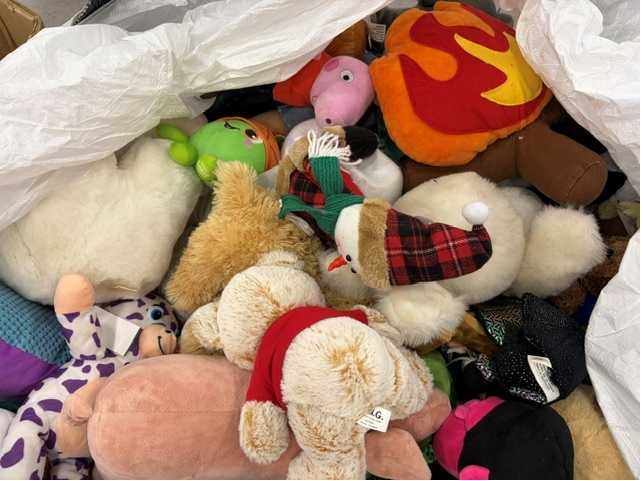 Assorted plush toys in a white sack